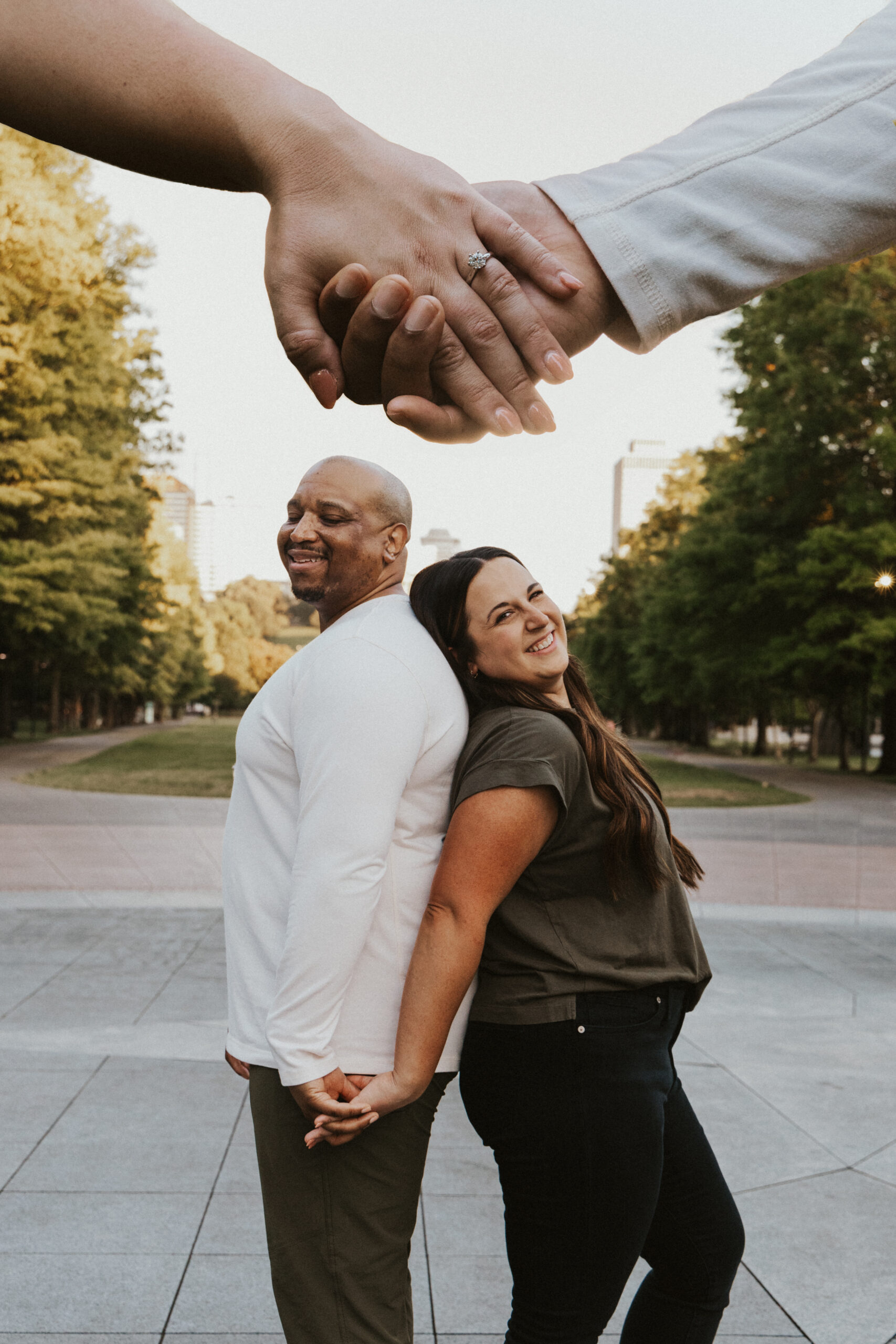 Double exposure image of engagement couple with their joined hands above.